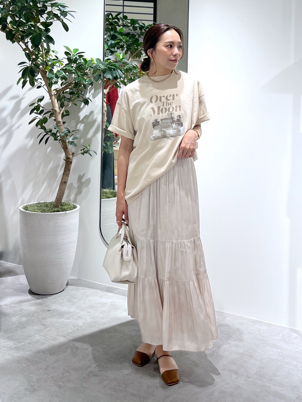 ベージュ系のTシャツ/カットソー、ホワイト系のショルダーバッグ、ホワイト系のスカートを着用したレディースの春コーディネートの4枚目の写真