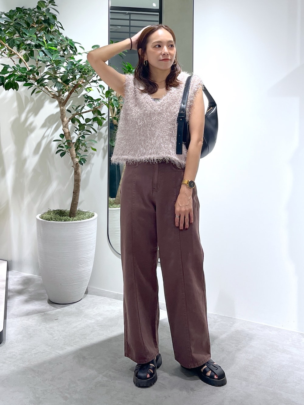 ベージュ系のニット/セーター、ブラック系のハンドバッグ、ブラウン系のデニムパンツを着用したレディースの夏コーディネートの9枚目の写真