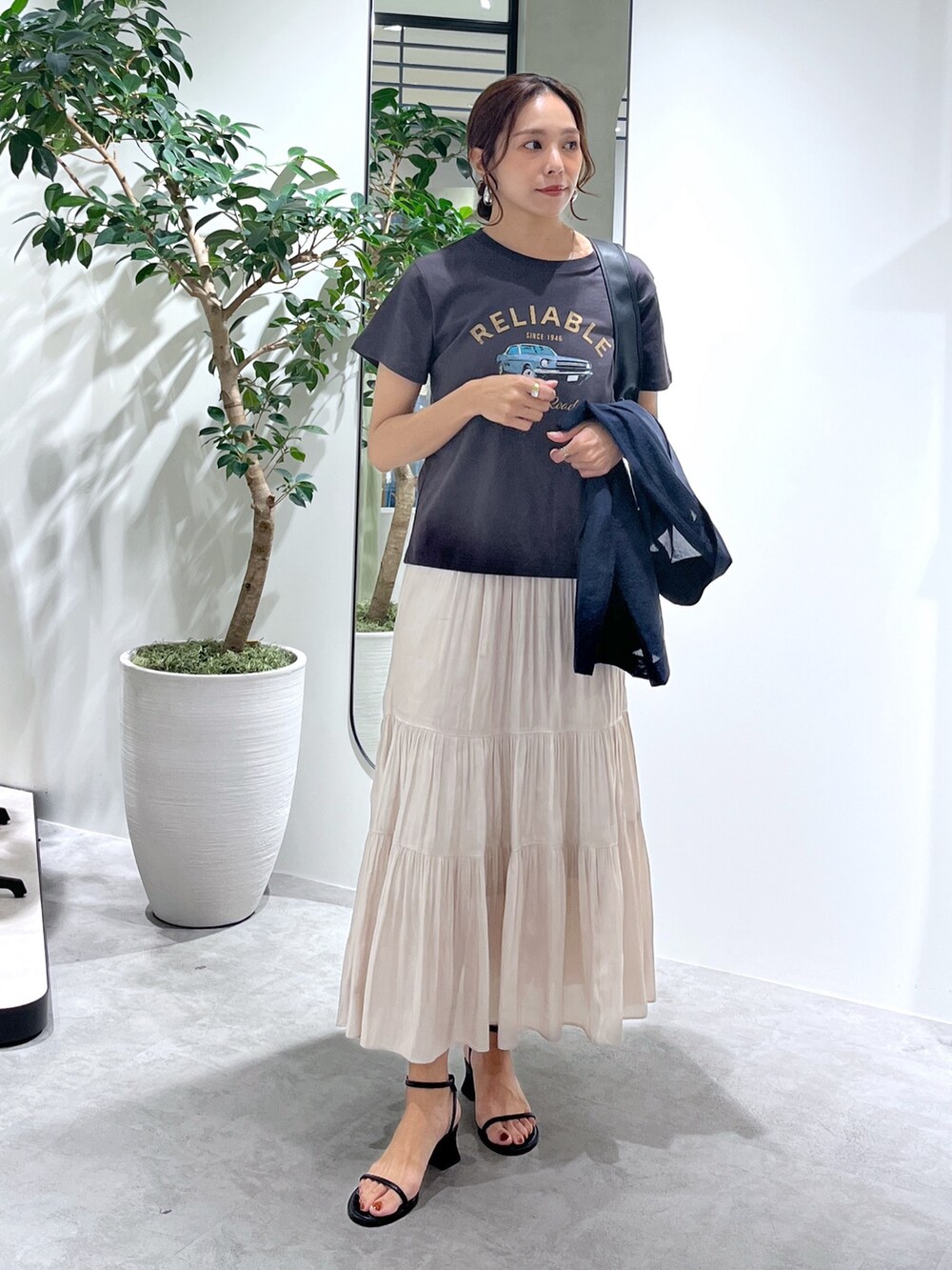 ブルー系のテーラードジャケット、ブラック系のハンドバッグ、ホワイト系のスカートを着用したレディースの夏コーディネートの9枚目の写真