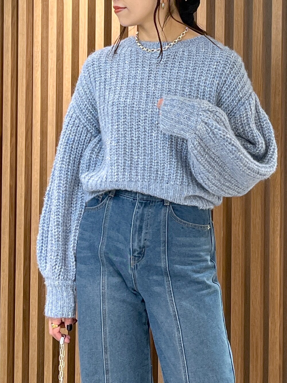 ブルー系のニット/セーター、ブルー系のデニムパンツ、ブラック系のハンドバッグを着用したレディースの冬コーディネートの10枚目の写真