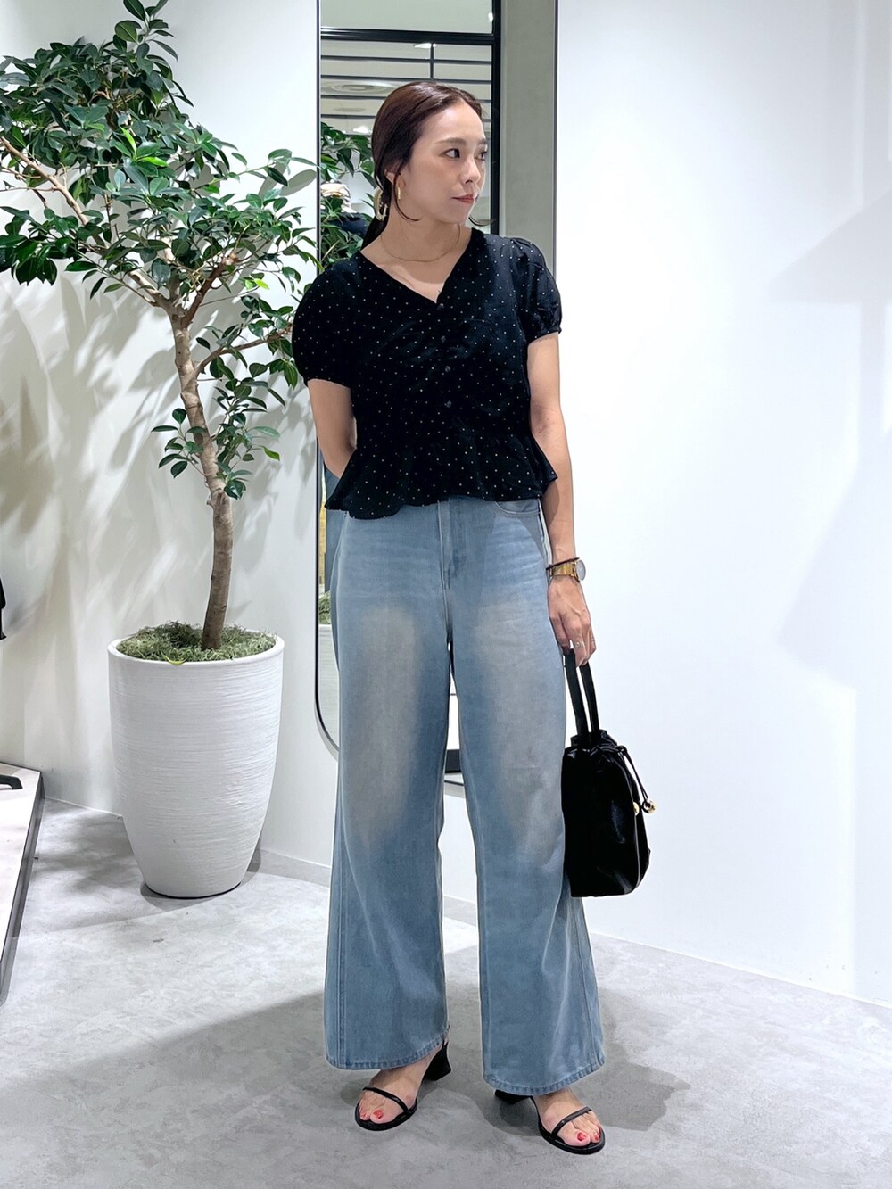 ブラック系のショルダーバッグ、ブルー系のデニムパンツ、ブラック系のシャツ/ブラウスを着用したレディースの夏コーディネートの4枚目の写真