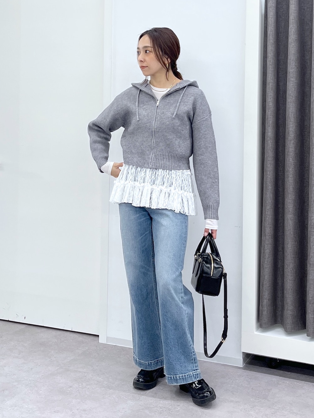 ブラック系のショルダーバッグ、ブルー系のデニムパンツ、ホワイト系のTシャツ/カットソーを着用したレディースの冬コーディネートの2枚目の写真