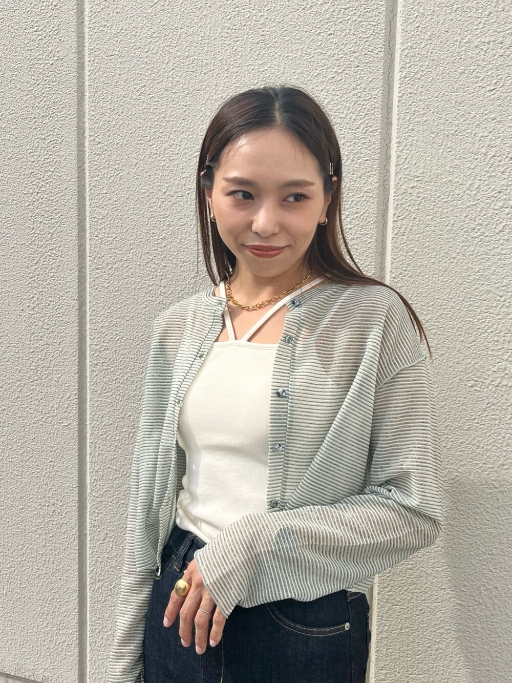 ブルー系のデニムパンツ、ホワイト系のキャミソール、グリーン系のカーディガン/ボレロを着用したレディースの夏コーディネートの4枚目の写真