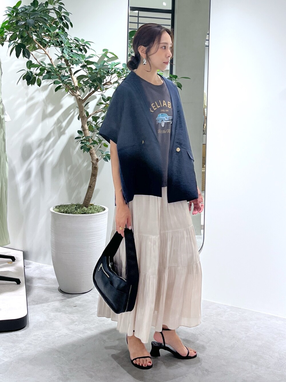 ブルー系のテーラードジャケット、ブラック系のハンドバッグ、ホワイト系のスカートを着用したレディースの夏コーディネートの8枚目の写真