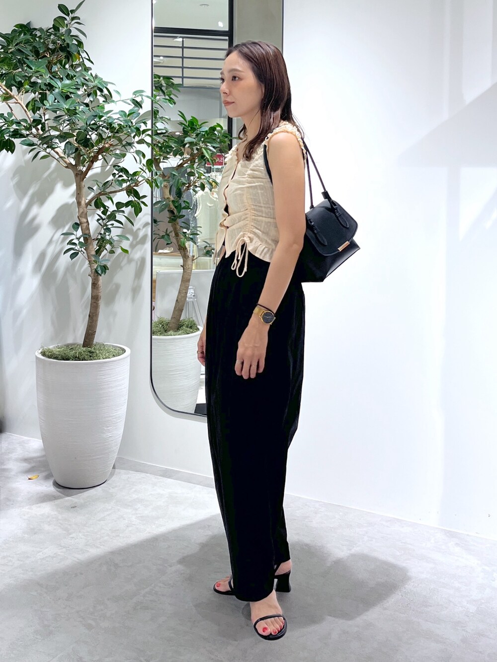 ブラック系のショルダーバッグ、ブラック系のパンツ、イエロー系のシャツ/ブラウスを着用したレディースの夏コーディネートの6枚目の写真