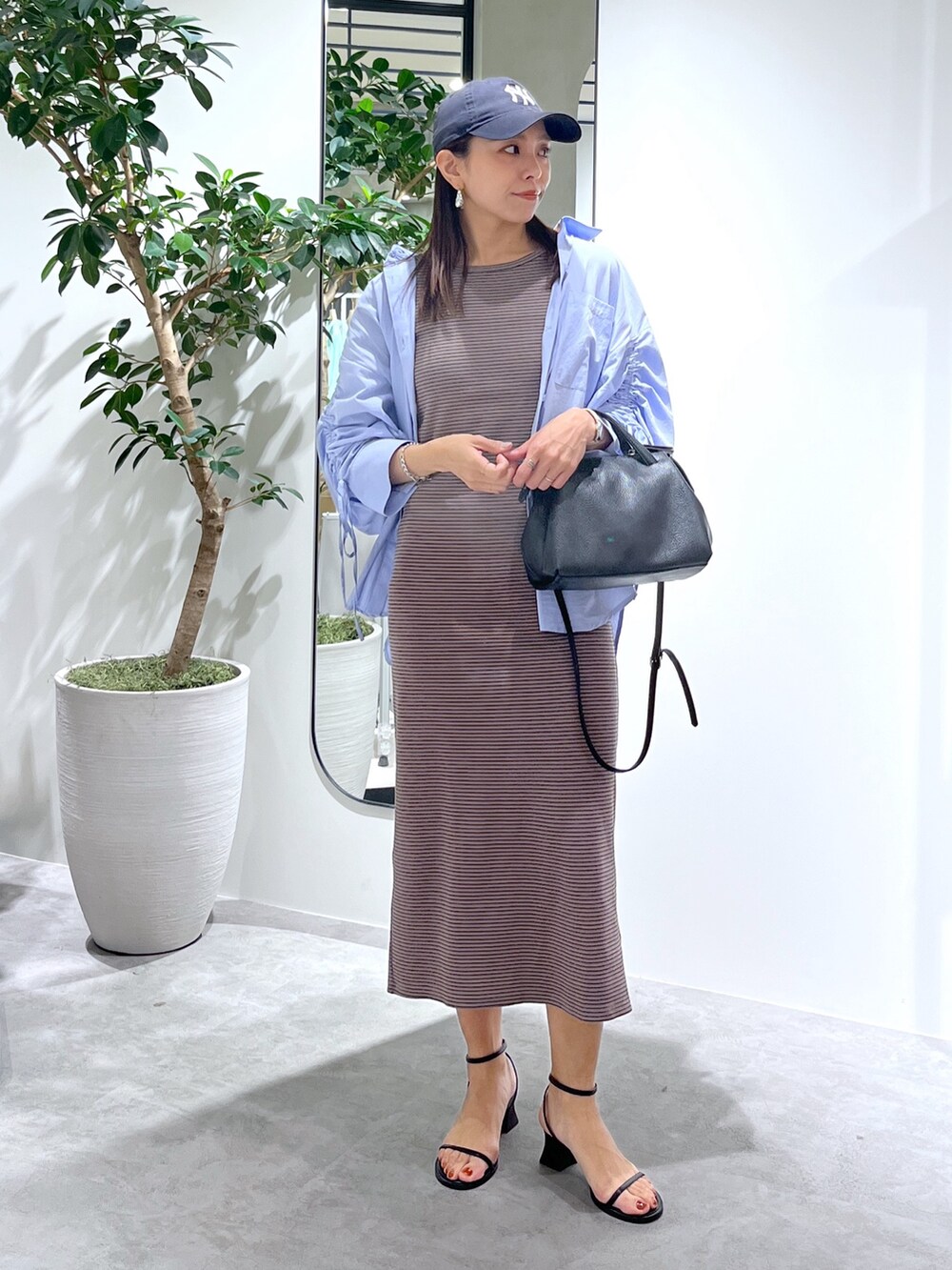 ブラウン系のワンピース、ブルー系のシャツ/ブラウス、ブラック系のショルダーバッグを着用したレディースの春コーディネートの10枚目の写真