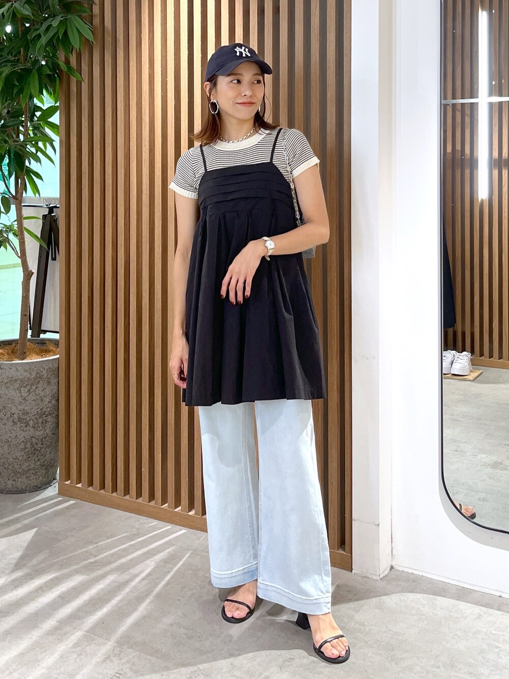 ブラック系のサンダル、ブルー系のデニムパンツ、ブラック系のワンピースを着用したレディースの夏コーディネートの2枚目の写真