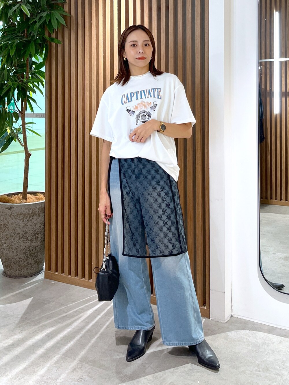 ホワイト系のTシャツ/カットソー、ブラック系のハンドバッグ、ブラック系のスカートを着用したレディースの秋コーディネートの2枚目の写真