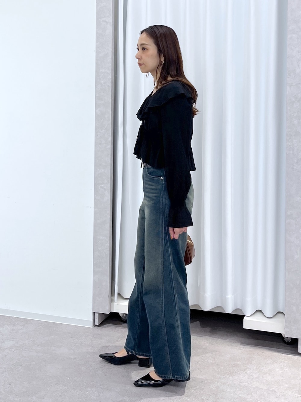 ブラック系のシャツ/ブラウス、ブルー系のデニムパンツ、ブラウン系のハンドバッグを着用したレディースの春コーディネートの5枚目の写真