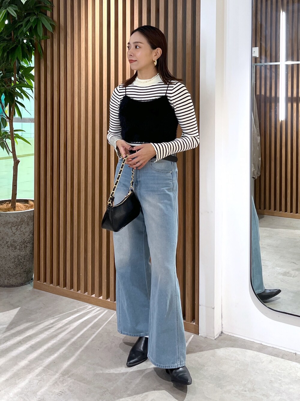 ブラック系のキャミソール、ホワイト系のニット/セーター、ブラック系のトートバッグを着用したレディースの秋コーディネートの10枚目の写真