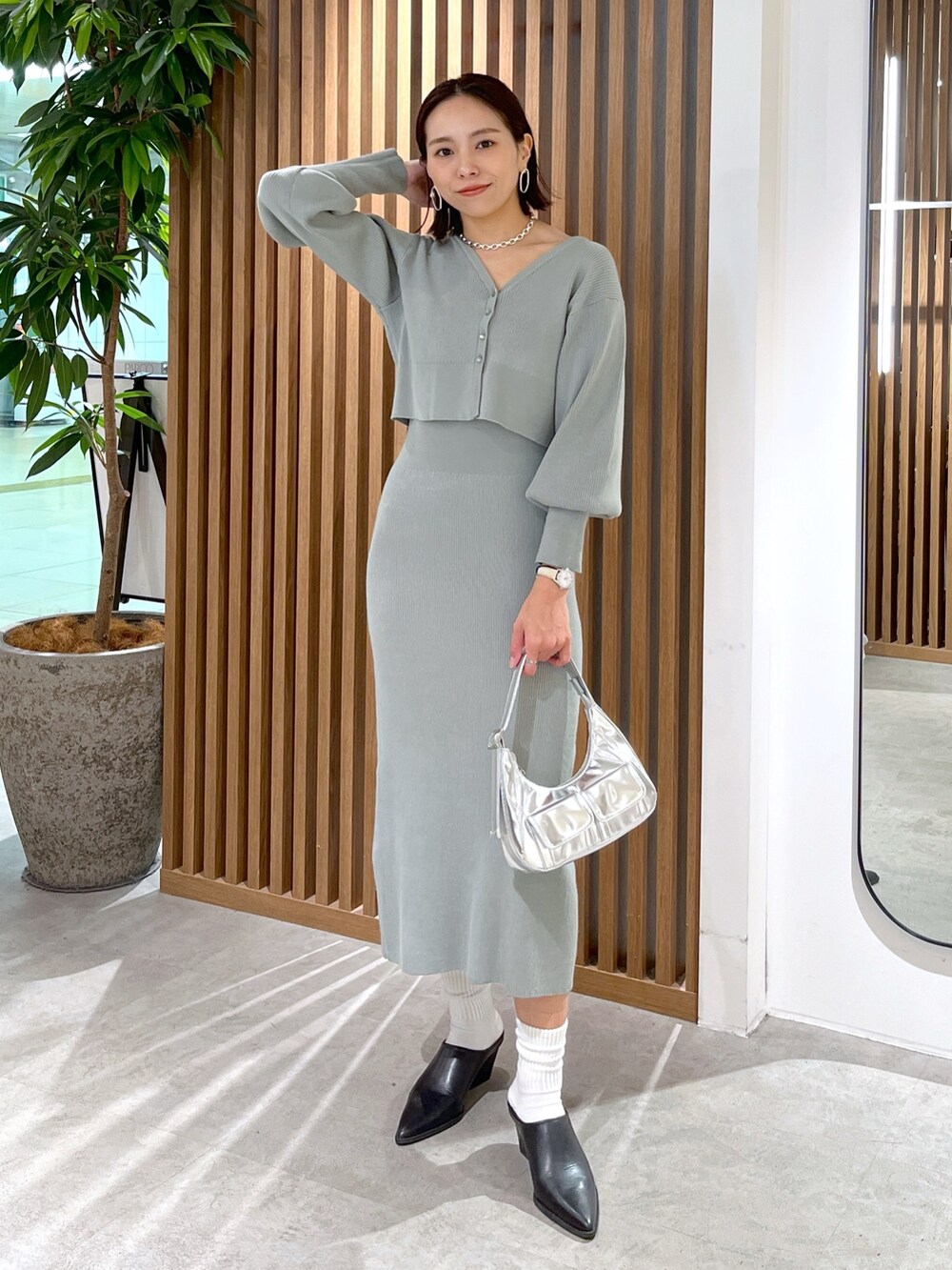 グリーン系のカーディガン/ボレロ、シルバー系のショルダーバッグ、グリーン系のワンピースを着用したレディースの冬コーディネートの5枚目の写真