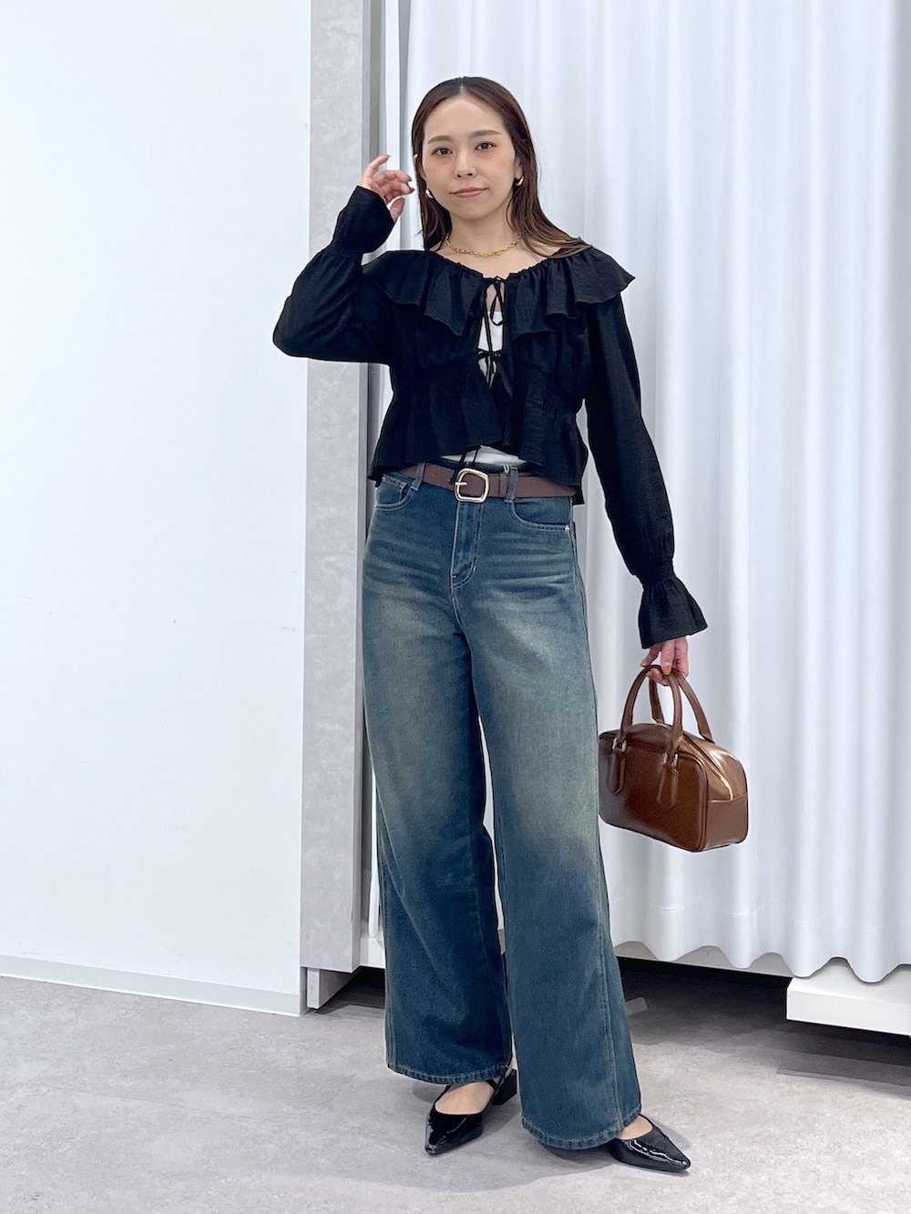 ブラック系のシャツ/ブラウス、ブルー系のデニムパンツ、ブラウン系のハンドバッグを着用したレディースの春コーディネートの8枚目の写真