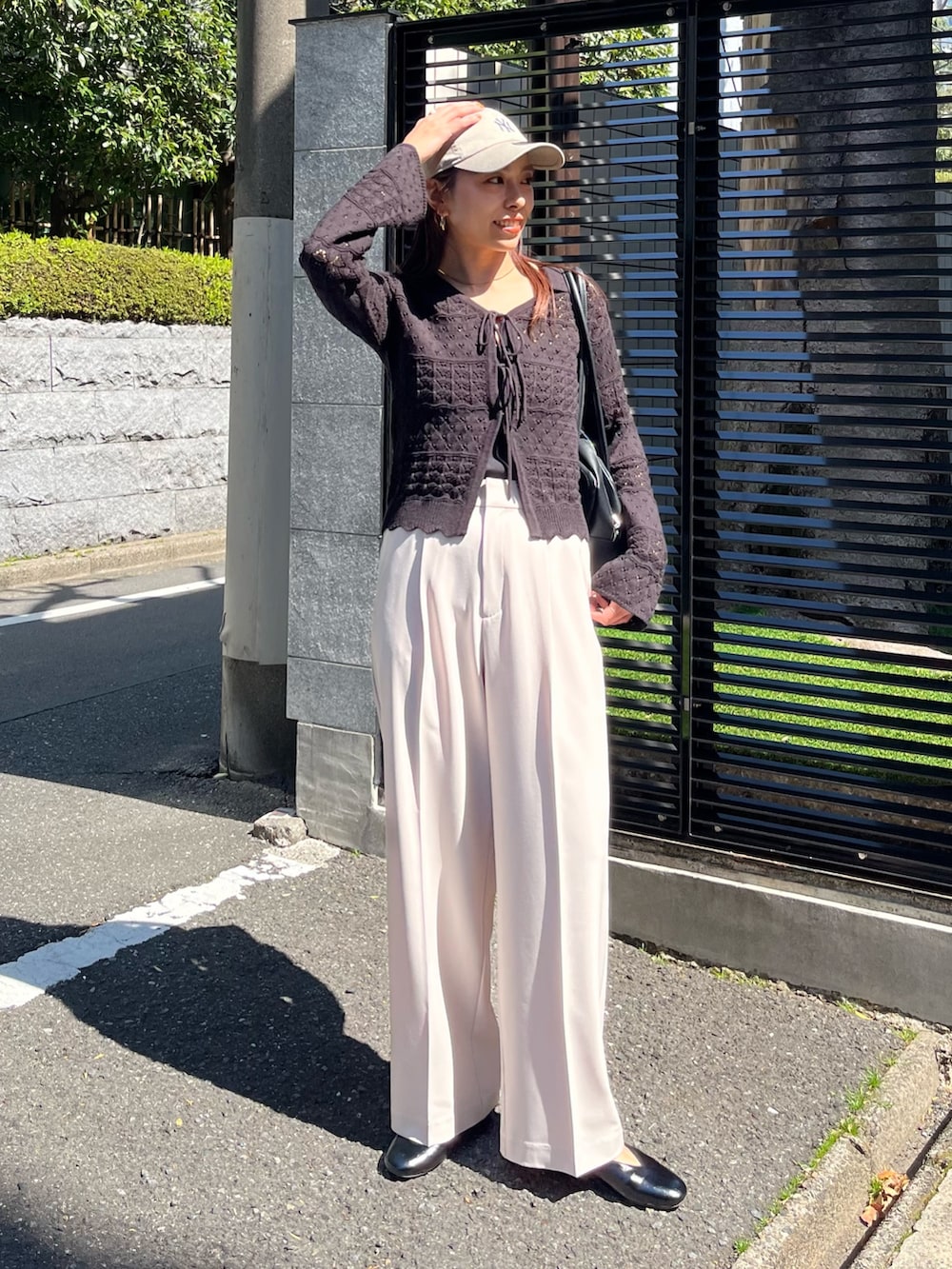 ブラック系のニット/セーター、ベージュ系のスラックス、ブラック系のパンプスを着用したレディースの春コーディネートの6枚目の写真