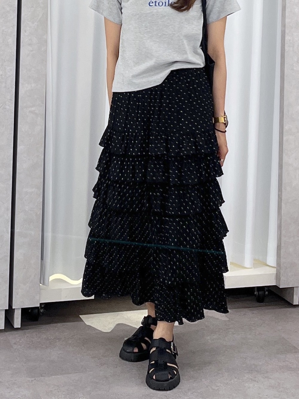 ブラック系のトートバッグ、ブラック系のスカート、グレー系のTシャツ/カットソーを着用したレディースの春コーディネートの6枚目の写真