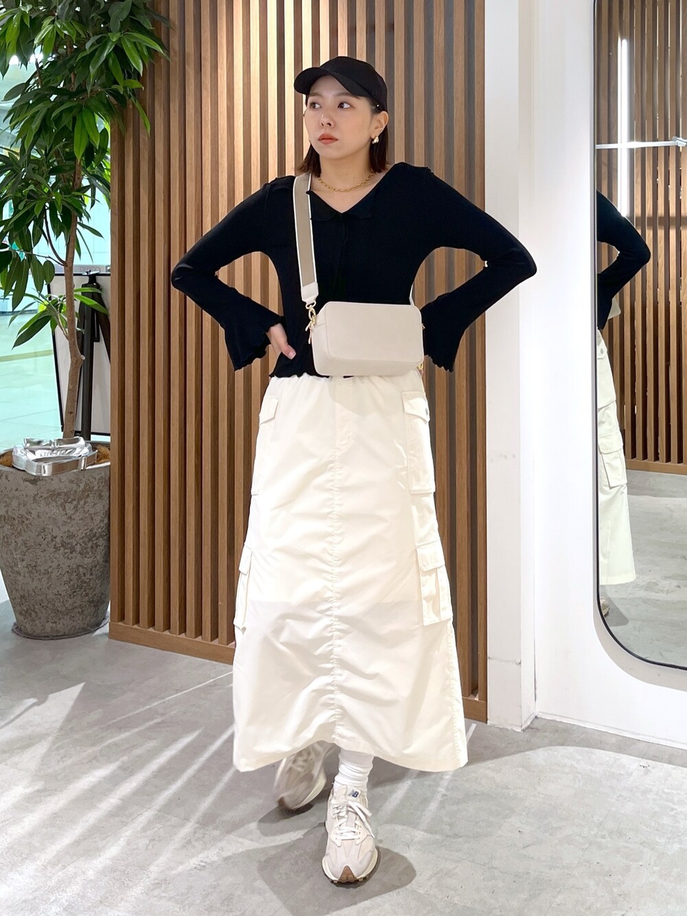 ホワイト系のボディバッグ/ウエストポーチ、ブラック系のトップス、ホワイト系のスカートを着用したレディースの春コーディネートの2枚目の写真