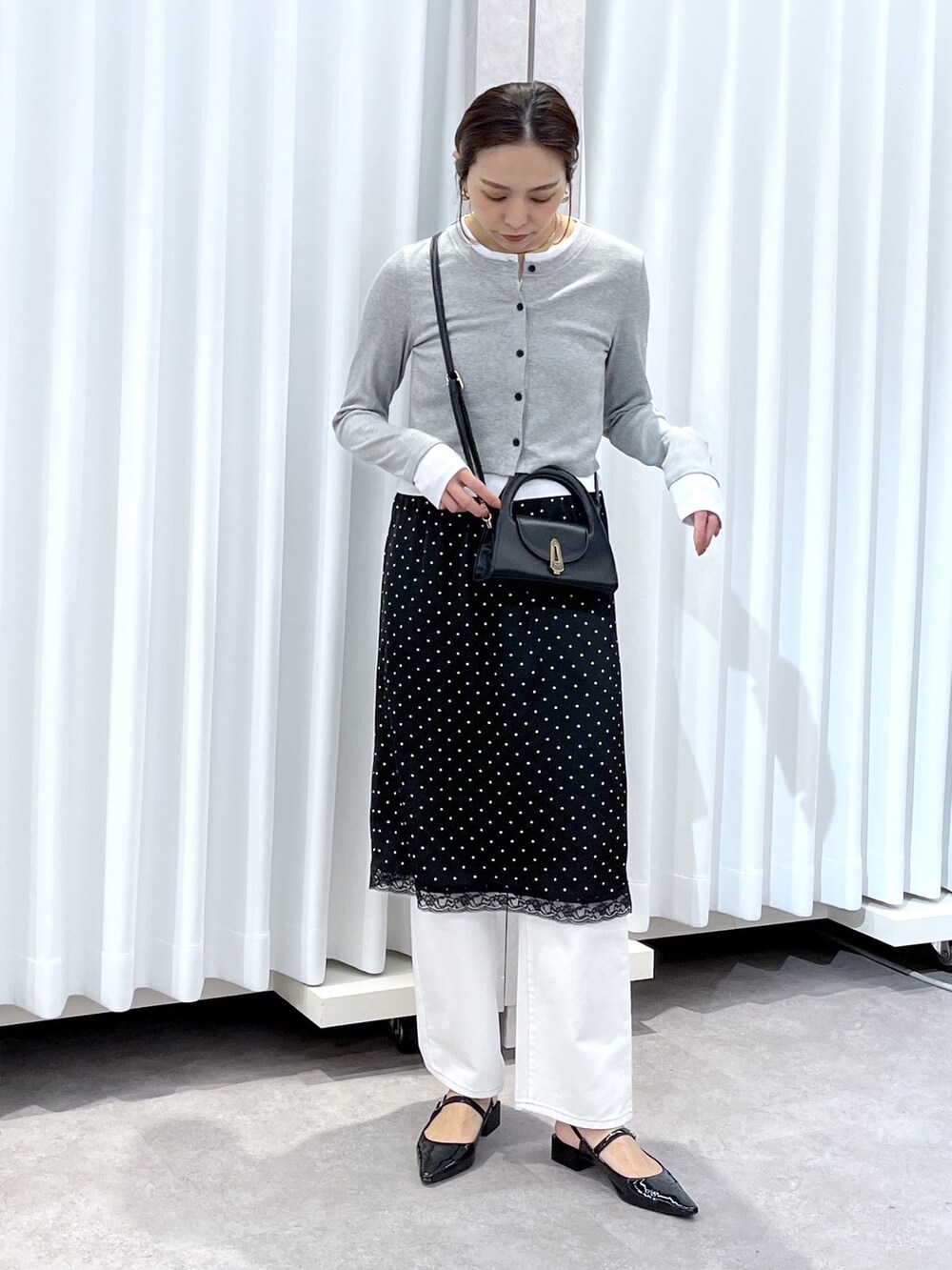 ブラック系のスカート、グレー系のTシャツ/カットソー、ホワイト系のデニムパンツを着用したレディースの春コーディネートの8枚目の写真