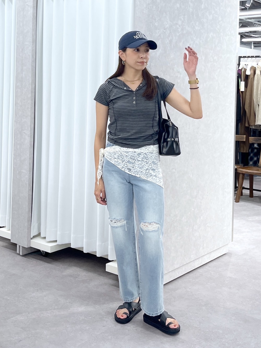ブラック系のショルダーバッグ、グレー系のTシャツ/カットソー、ブルー系のデニムパンツを着用したレディースの夏コーディネートの6枚目の写真