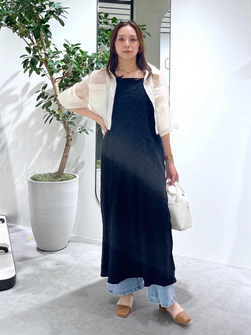 ホワイト系のシャツ/ブラウス、ブラック系のワンピース、ホワイト系のトートバッグを着用したレディースの春コーディネートの2枚目の写真