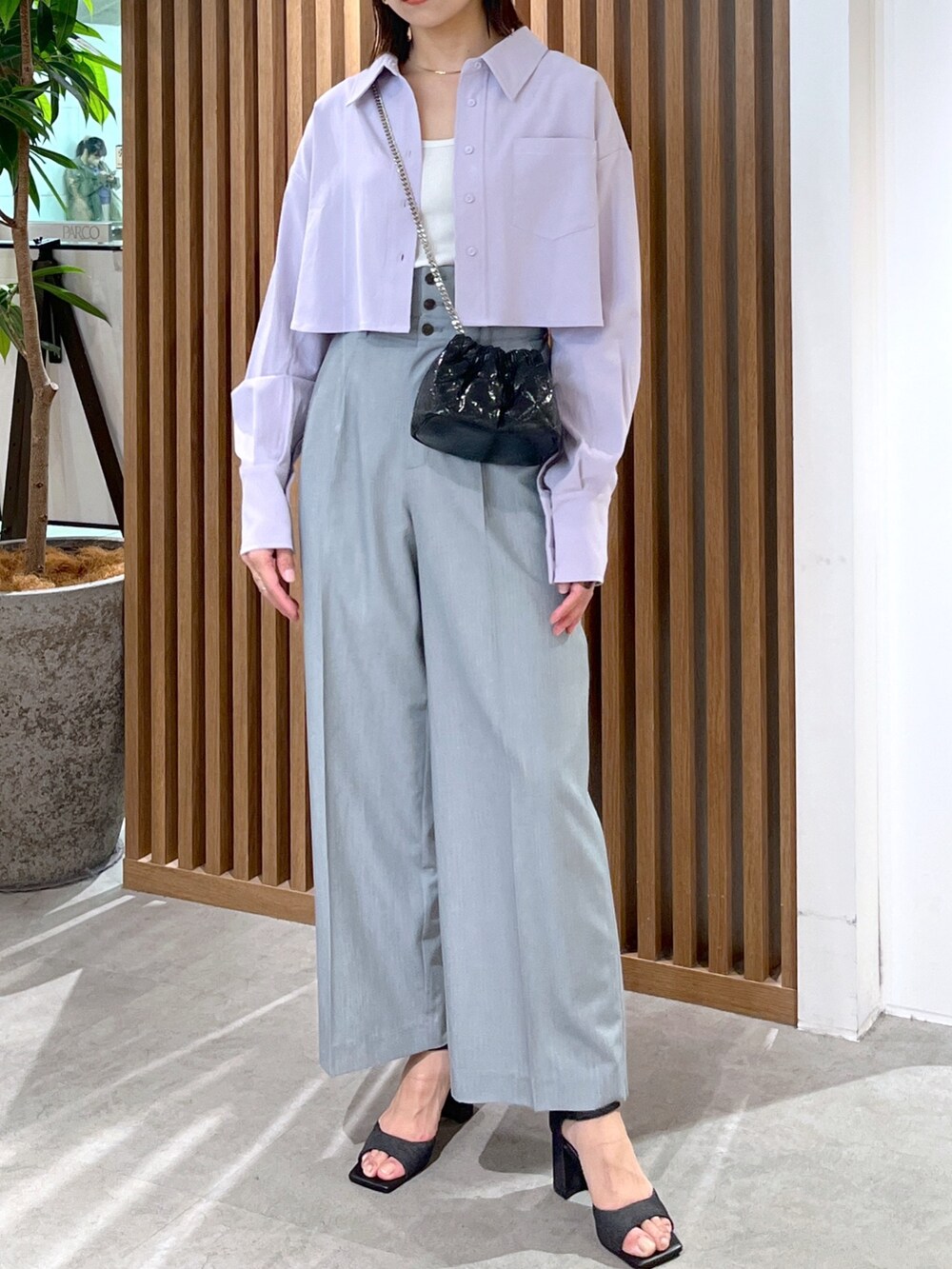 ブラック系のサンダル、グレー系のスラックス、ブラック系のショルダーバッグを着用したレディースの春コーディネートの8枚目の写真