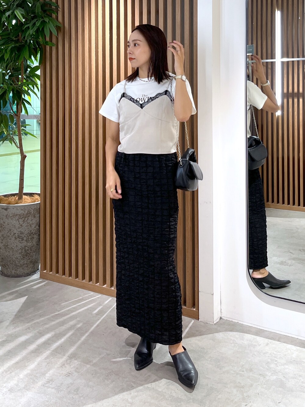 ブラック系のスカート、ホワイト系のTシャツ/カットソー、グレー系のキャミソールを着用したレディースの秋コーディネートの3枚目の写真