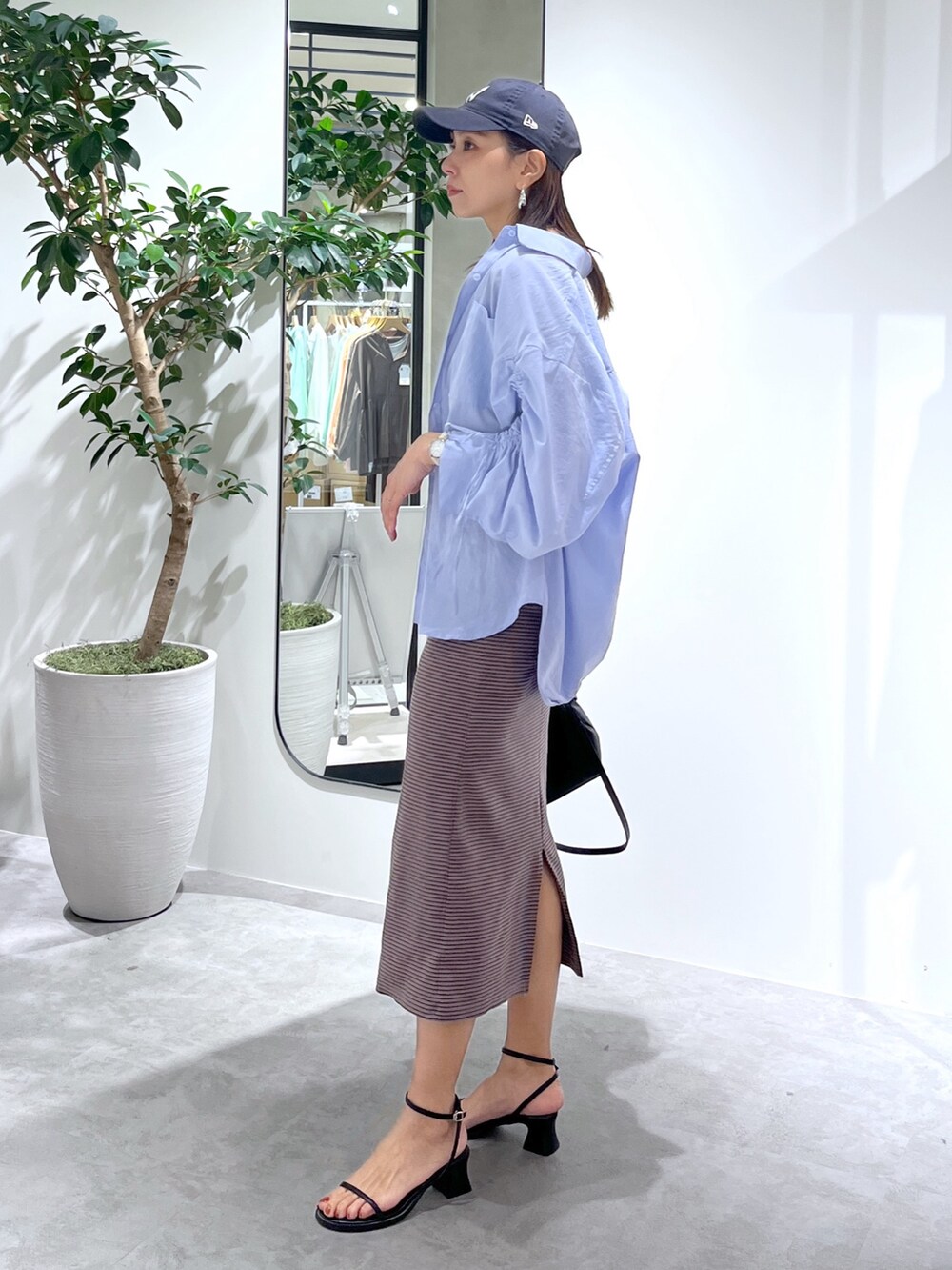 ブラウン系のワンピース、ブルー系のシャツ/ブラウス、ブラック系のショルダーバッグを着用したレディースの春コーディネートの4枚目の写真