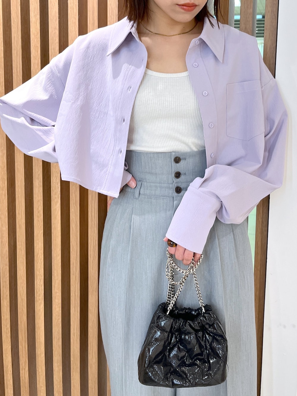 ブラック系のサンダル、グレー系のスラックス、ブラック系のショルダーバッグを着用したレディースの春コーディネートの6枚目の写真