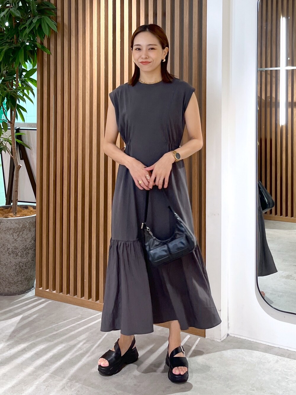 ブラック系のワンピース、ホワイト系のシャツ/ブラウス、ブラック系のサンダルを着用したレディースの夏コーディネートの8枚目の写真