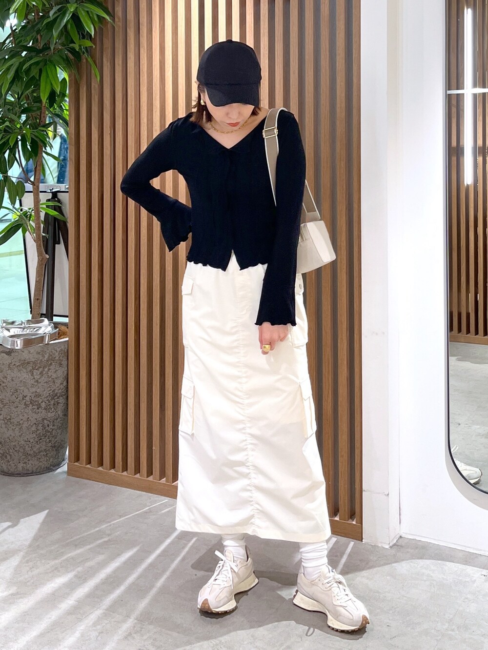 ホワイト系のボディバッグ/ウエストポーチ、ブラック系のトップス、ホワイト系のスカートを着用したレディースの春コーディネートの4枚目の写真