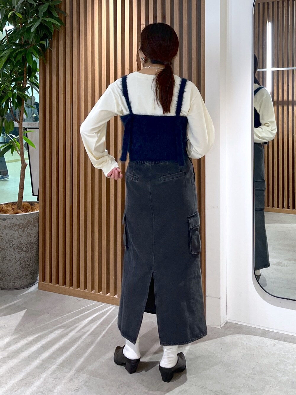 ベージュ系のTシャツ/カットソー、ブルー系のベスト、シルバー系のハンドバッグを着用したレディースの冬コーディネートの5枚目の写真