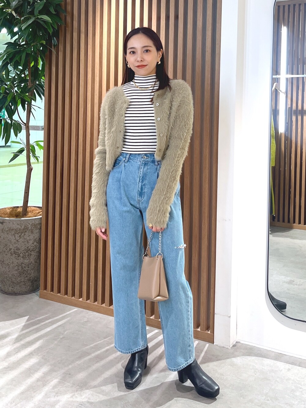 ベージュ系のカーディガン/ボレロ、ブルー系のデニムパンツ、ホワイト系のニット/セーターを着用したレディースの冬コーディネートの9枚目の写真