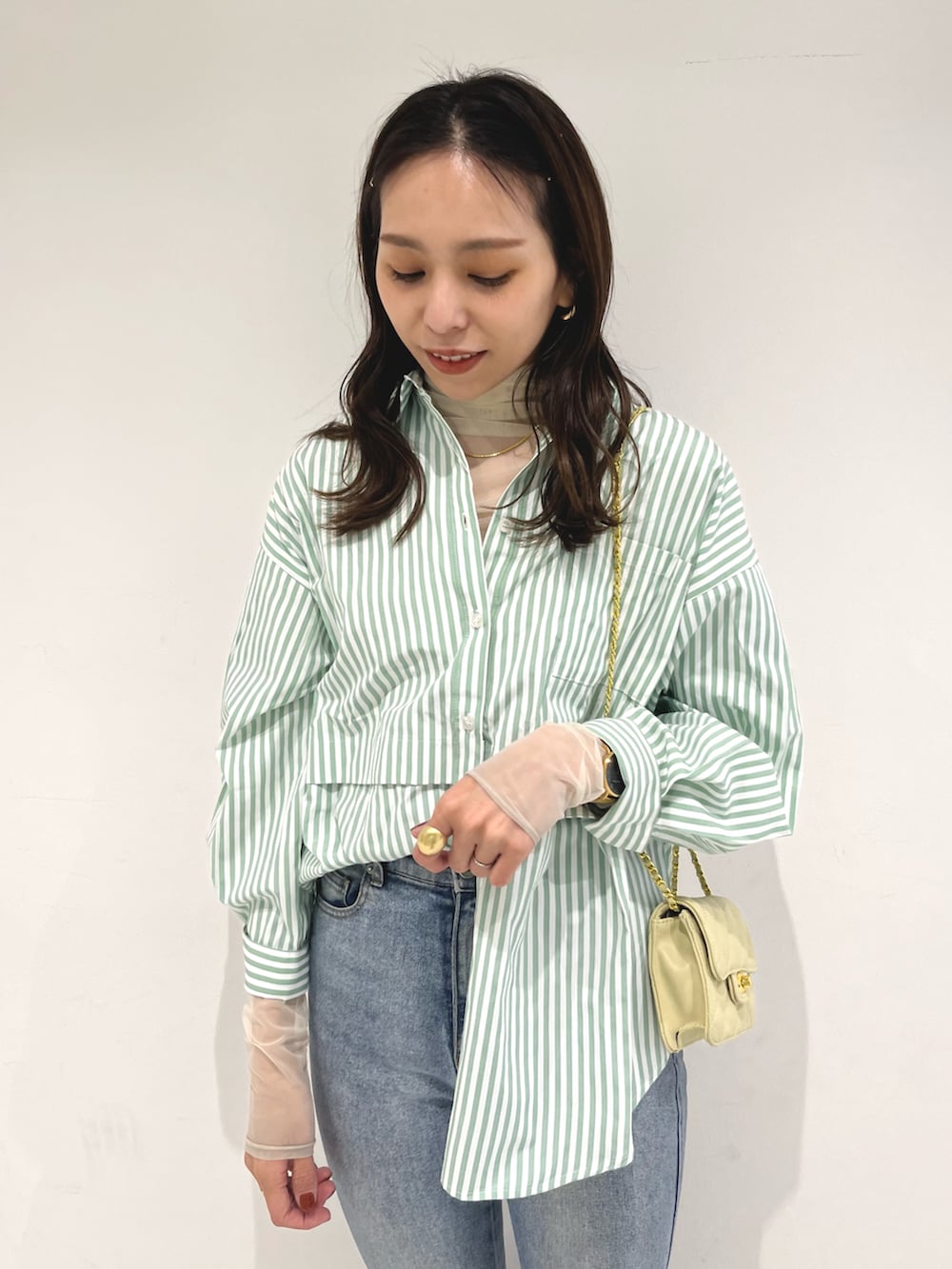 ブルー系のデニムパンツ、グリーン系のシャツ/ブラウス、イエロー系のショルダーバッグを着用したレディースの冬コーディネートの4枚目の写真