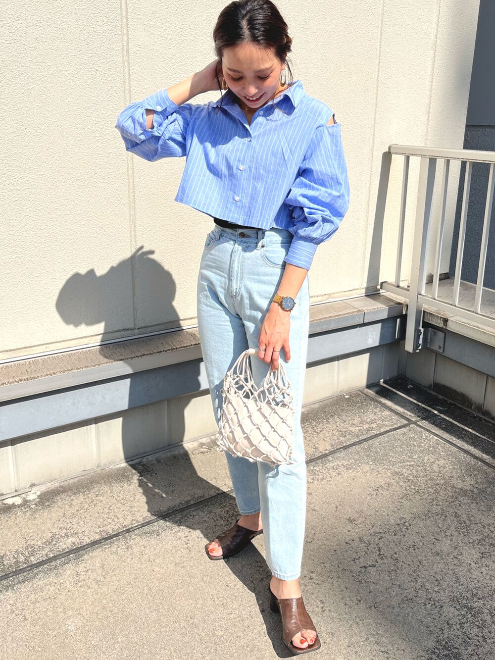 ブルー系のシャツ/ブラウス、ブルー系のデニムパンツを着用したレディースの春コーディネートの5枚目の写真