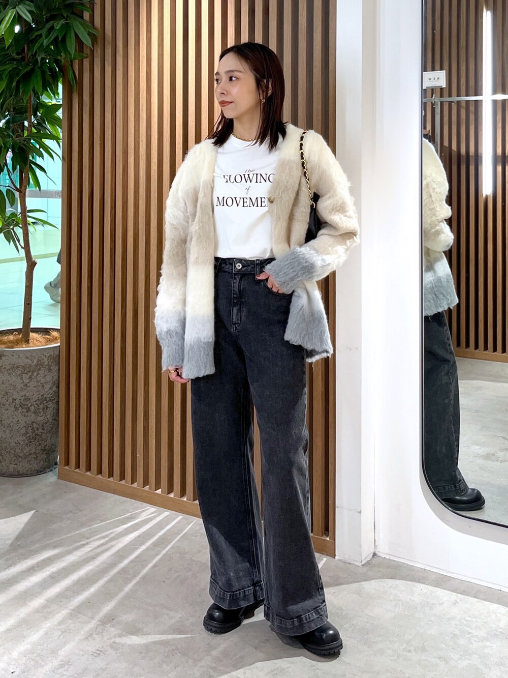 ベージュ系のカーディガン/ボレロ、ホワイト系のTシャツ/カットソー、ブラック系のトートバッグを着用したレディースの秋コーディネートの2枚目の写真