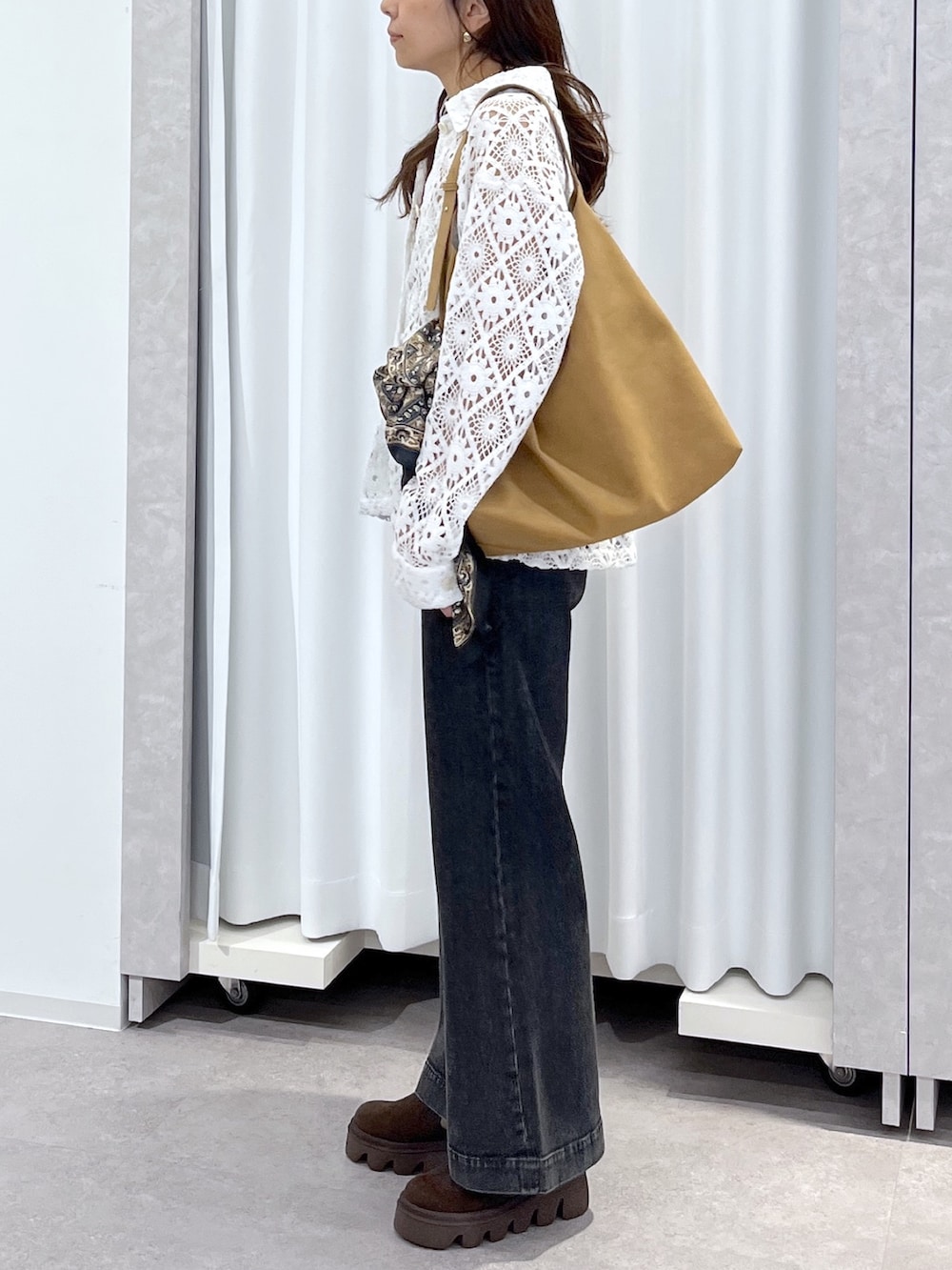 ホワイト系のブルゾン、ブラウン系のショルダーバッグ、ブラック系のデニムパンツを着用したレディースの春コーディネートの7枚目の写真