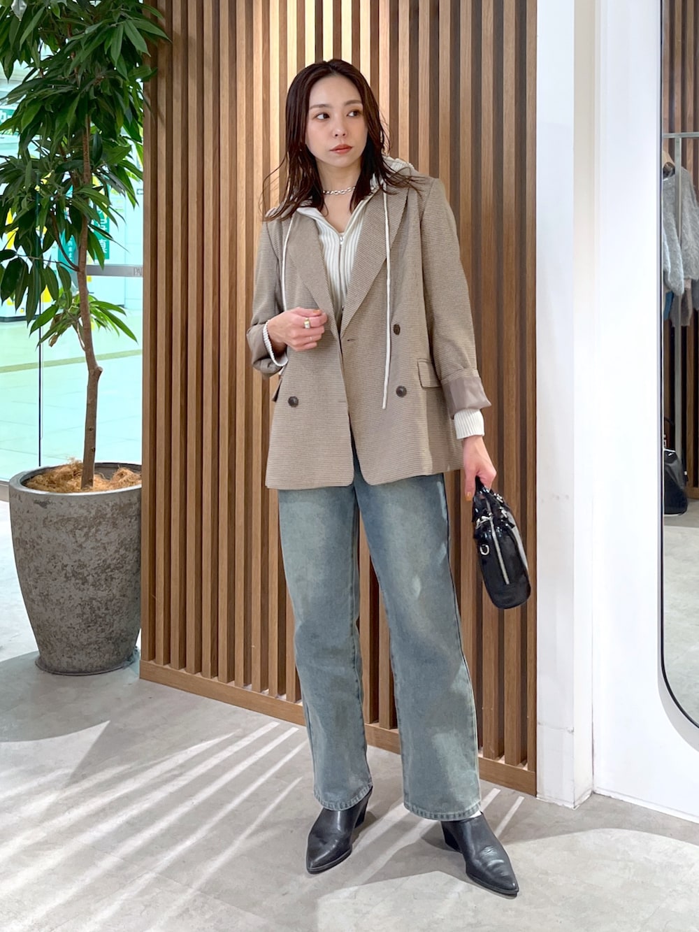 ホワイト系のニット/セーター、ベージュ系のテーラードジャケット、ブルー系のデニムパンツを着用したレディースの冬コーディネートの5枚目の写真