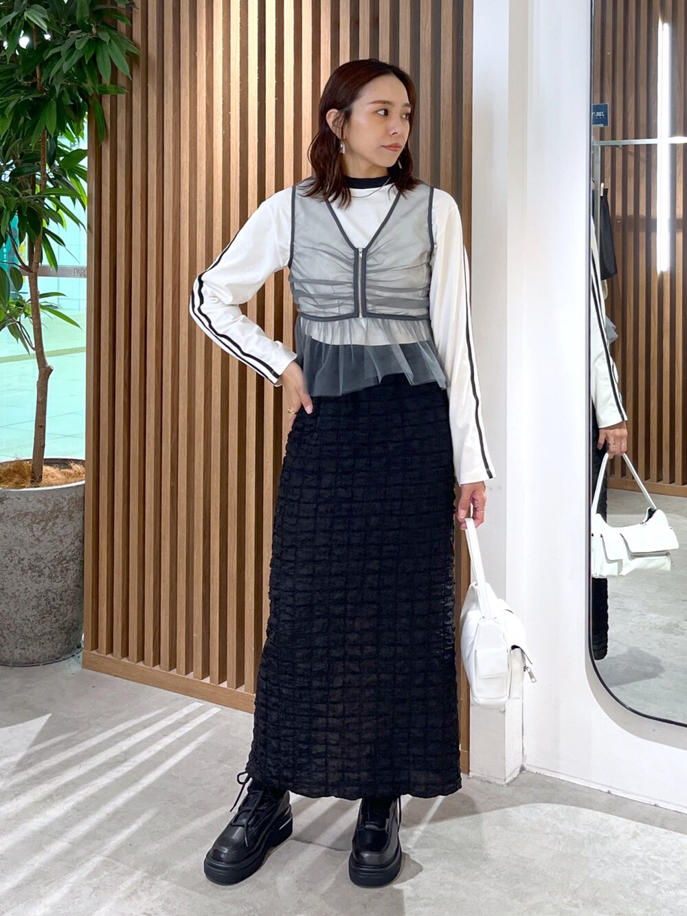 ホワイト系のTシャツ/カットソー、グレー系のシャツ/ブラウス、ブラック系のスカートを着用したレディースの秋コーディネートの3枚目の写真