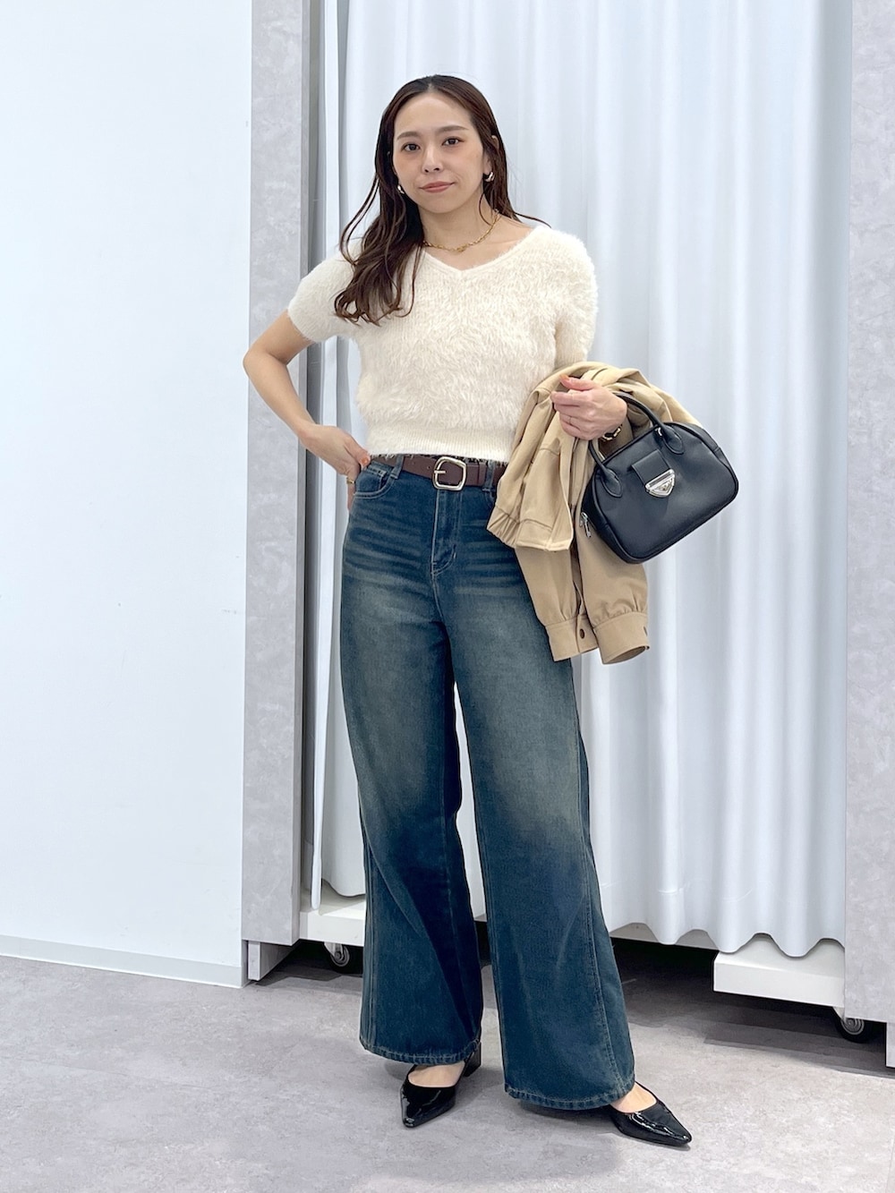 ベージュ系のブルゾン、ホワイト系のニット/セーター、ブルー系のデニムパンツを着用したレディースの春コーディネートの7枚目の写真