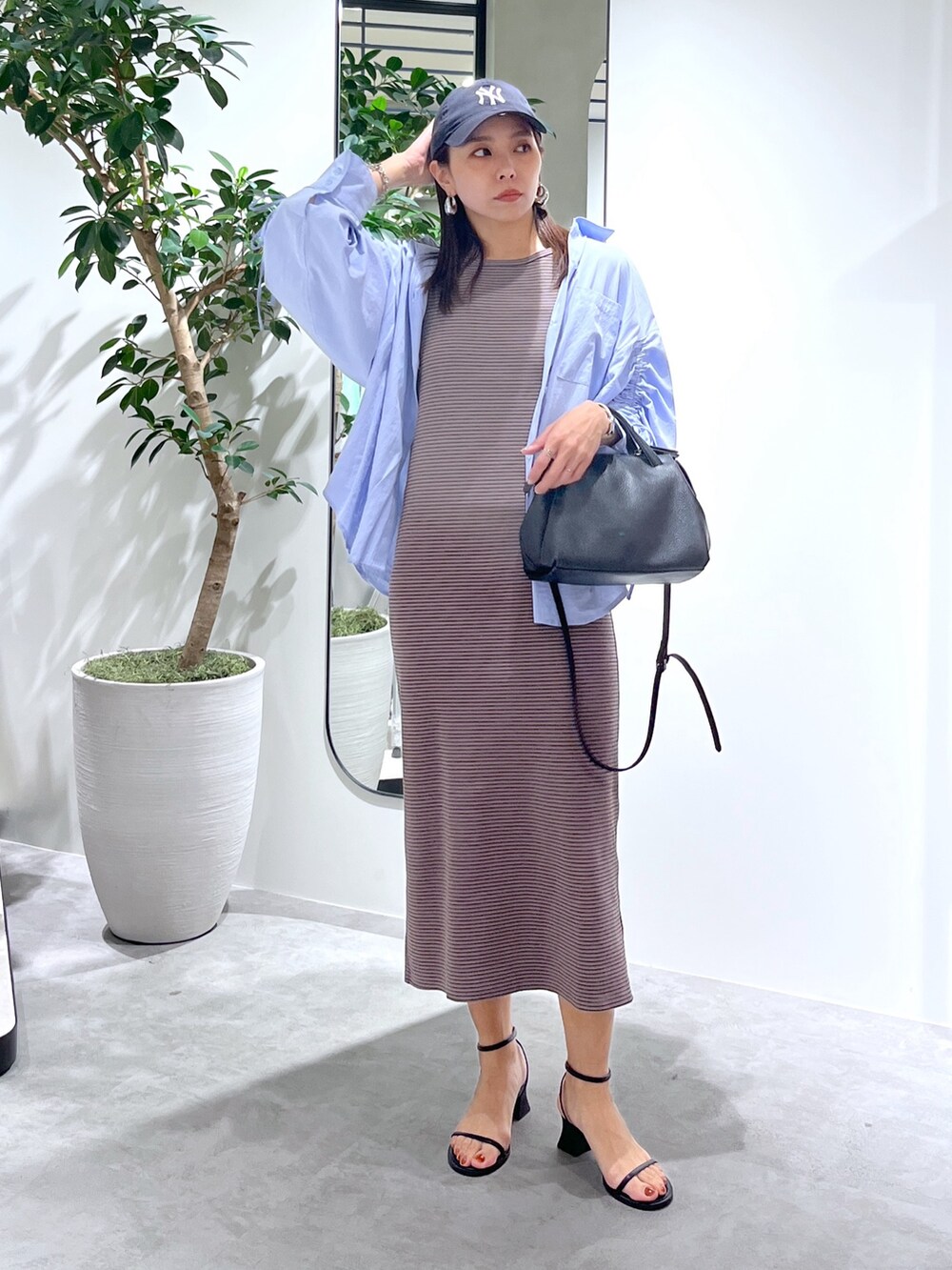 ブラウン系のワンピース、ブルー系のシャツ/ブラウス、ブラック系のショルダーバッグを着用したレディースの春コーディネートの5枚目の写真