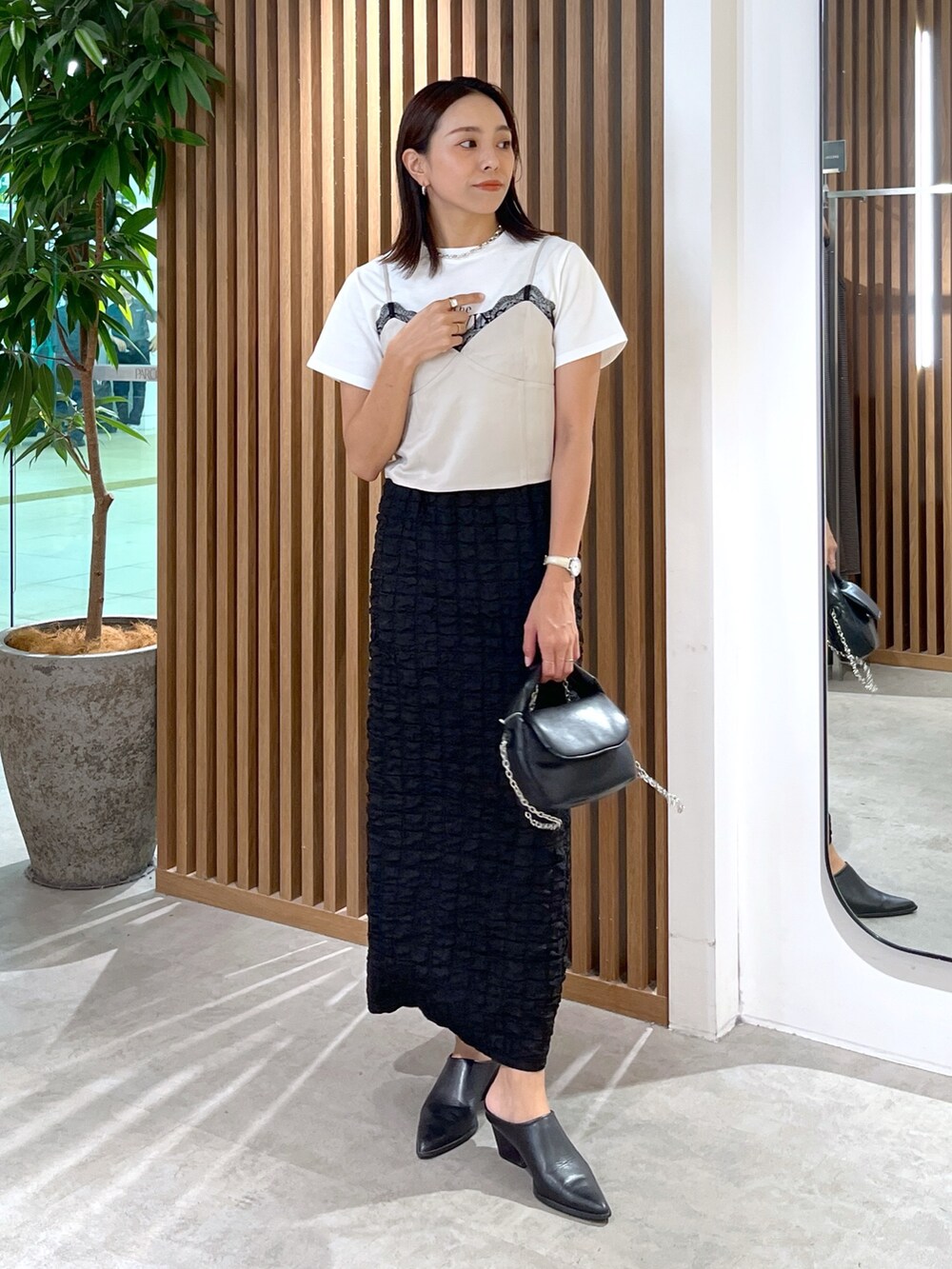 ブラック系のスカート、ホワイト系のTシャツ/カットソー、グレー系のキャミソールを着用したレディースの秋コーディネートの7枚目の写真