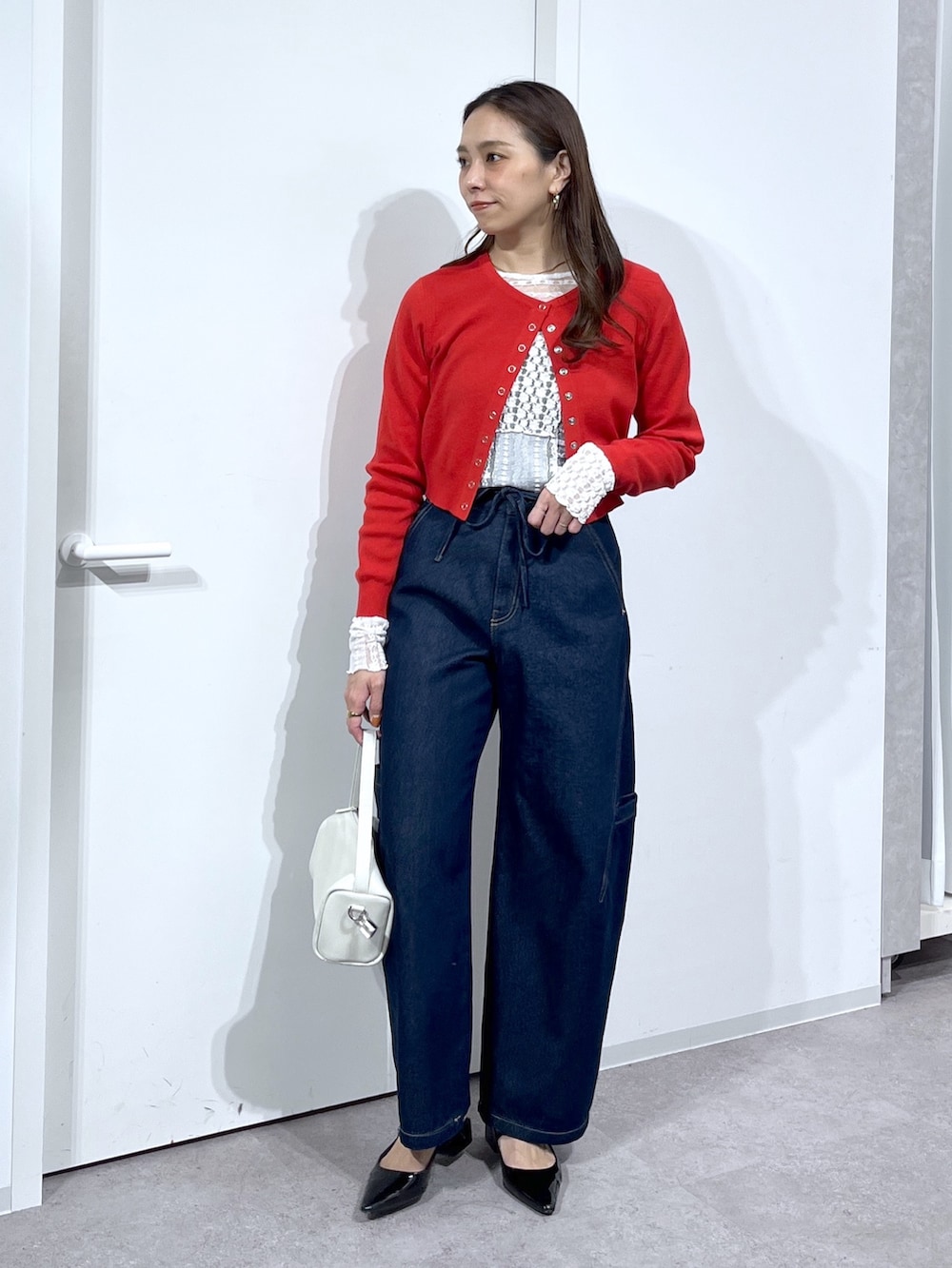 ホワイト系のTシャツ/カットソー、レッド系のニット/セーター、ブルー系のデニムパンツを着用したレディースの春コーディネートの8枚目の写真