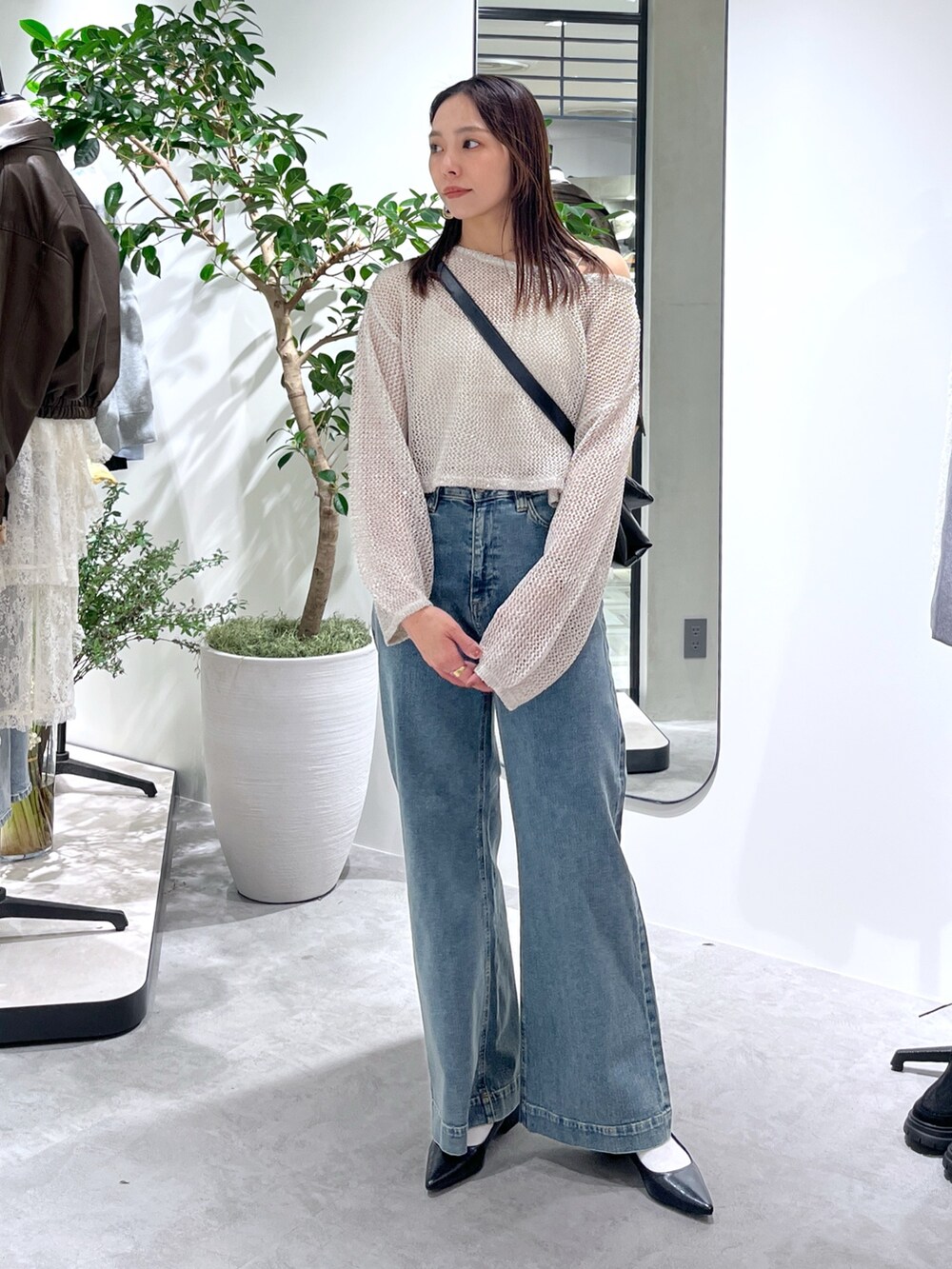 ホワイト系のニット/セーター、ホワイト系のキャミソール、ブラック系のショルダーバッグを着用したレディースの春コーディネートの4枚目の写真