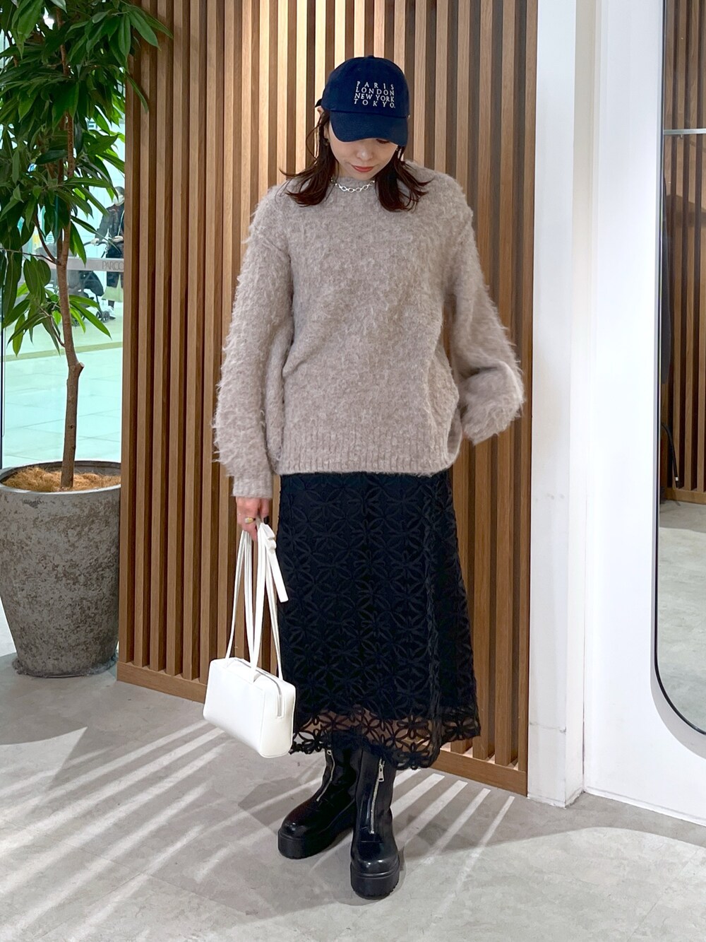 ホワイト系のショルダーバッグ、ベージュ系のニット/セーター、ブラック系のスカートを着用したレディースの冬コーディネートの8枚目の写真
