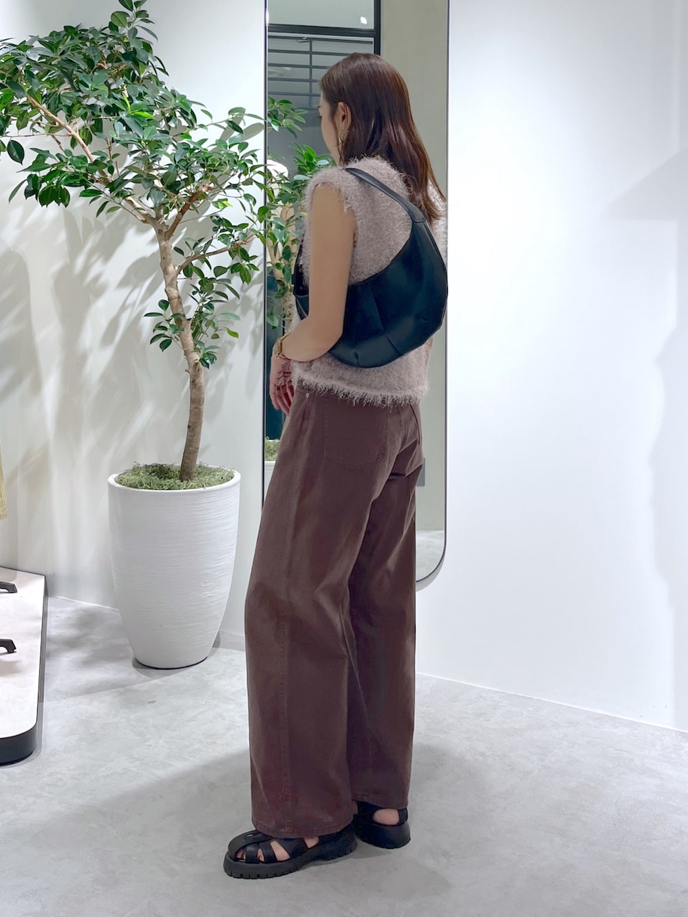 ベージュ系のニット/セーター、ブラック系のハンドバッグ、ブラウン系のデニムパンツを着用したレディースの夏コーディネートの6枚目の写真