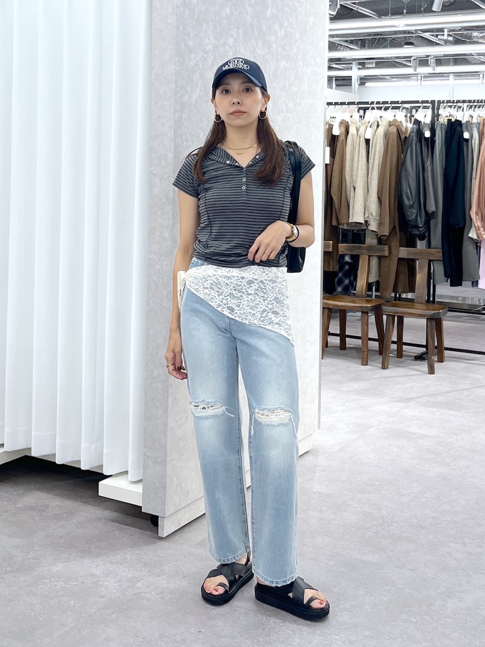 ブラック系のショルダーバッグ、グレー系のTシャツ/カットソー、ブルー系のデニムパンツを着用したレディースの夏コーディネートの3枚目の写真