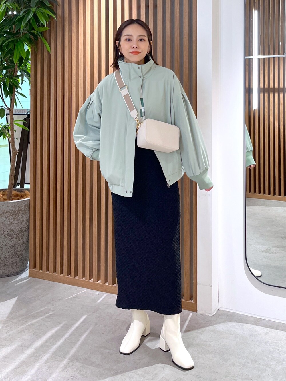 グリーン系のブルゾン、ホワイト系のTシャツ/カットソー、ホワイト系のボディバッグ/ウエストポーチを着用したレディースの春コーディネートの7枚目の写真