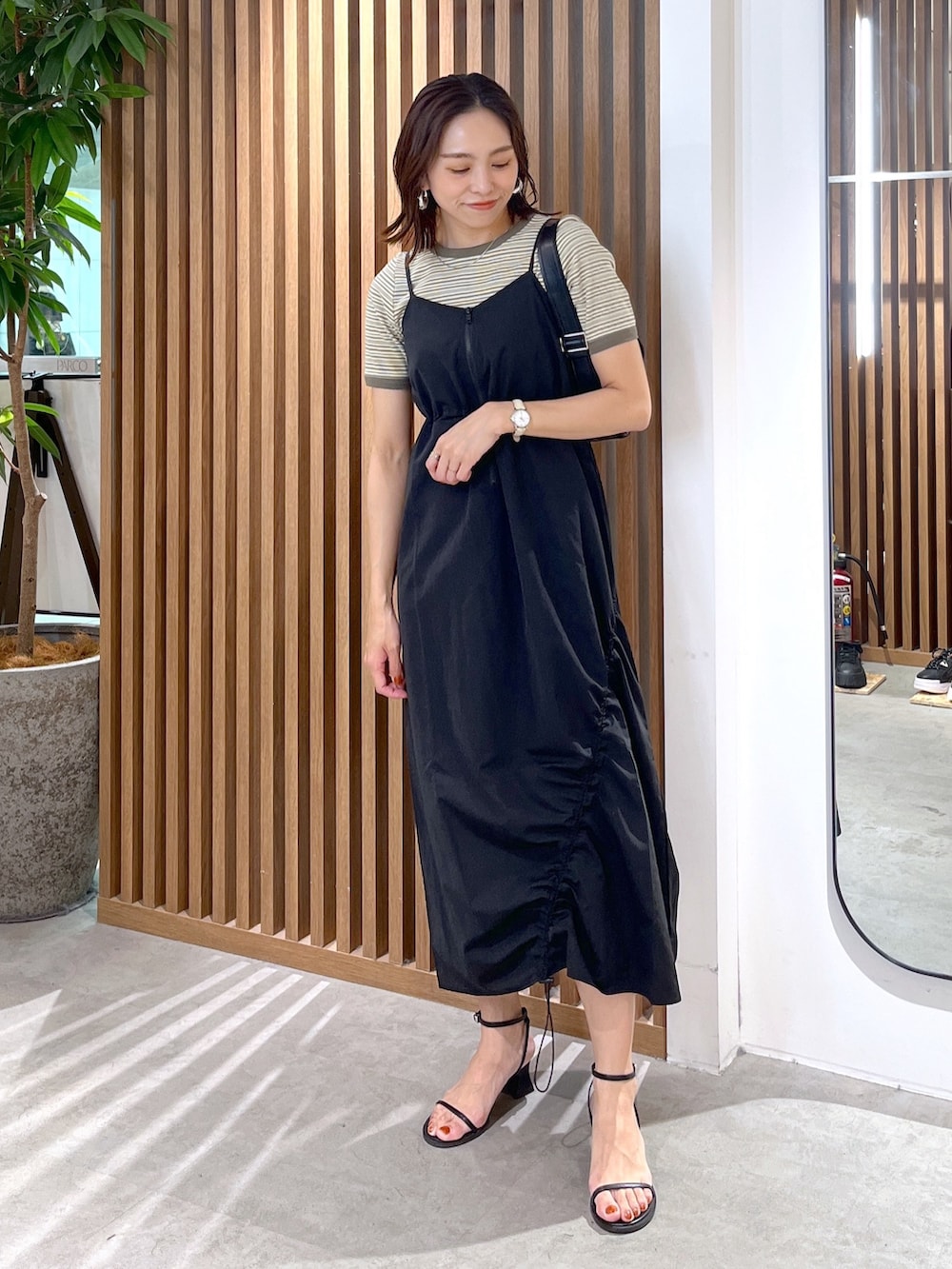 グリーン系のTシャツ/カットソー、ブラック系のショルダーバッグ、ブラック系のサンダルを着用したレディースの春コーディネートの9枚目の写真