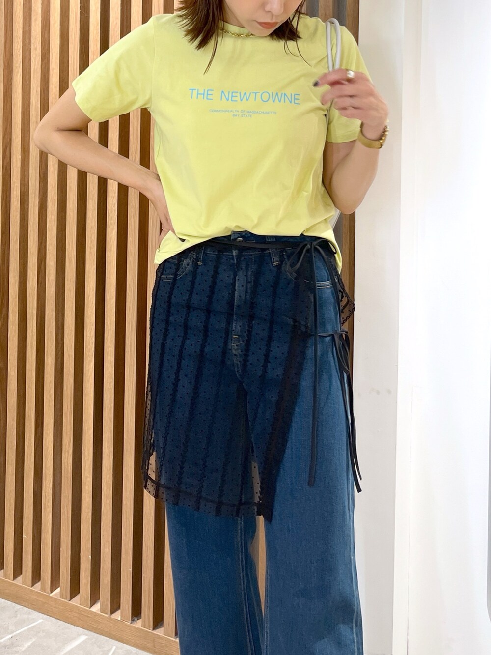 イエロー系のTシャツ/カットソー、ホワイト系のショルダーバッグ、ブラック系のスカートを着用したレディースの夏コーディネートの5枚目の写真