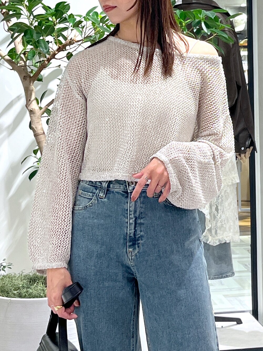 ホワイト系のニット/セーター、ホワイト系のキャミソール、ブラック系のショルダーバッグを着用したレディースの春コーディネートの5枚目の写真