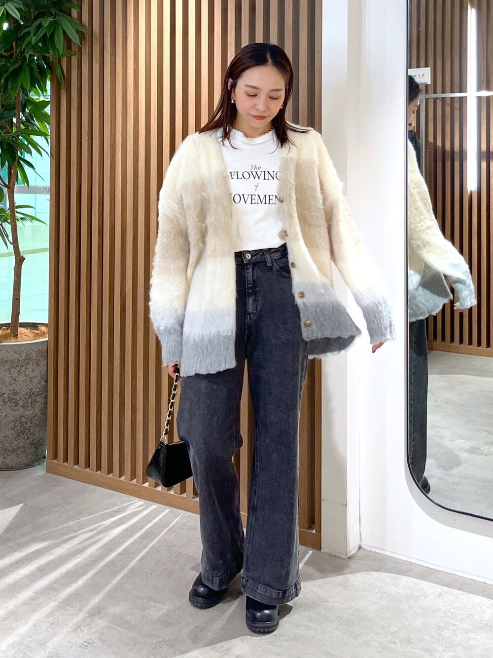 ベージュ系のカーディガン/ボレロ、ホワイト系のTシャツ/カットソー、ブラック系のトートバッグを着用したレディースの秋コーディネートの4枚目の写真