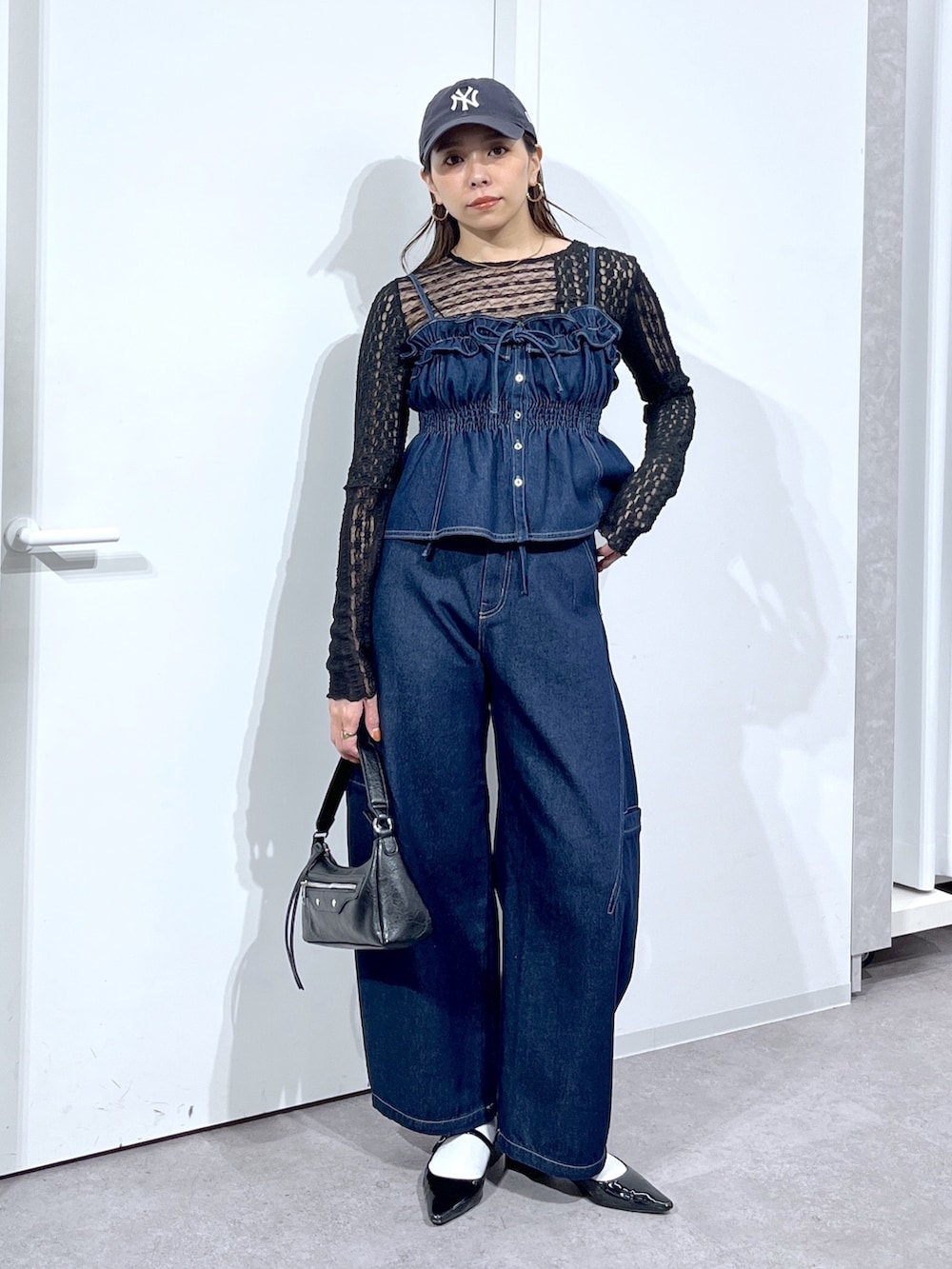 ブラック系のTシャツ/カットソー、ブルー系のシャツ/ブラウス、ブラック系のバッグを着用したレディースの春コーディネートの3枚目の写真